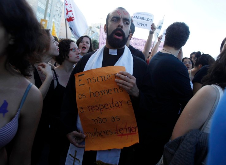 A man dressed as a priest participates in the SlutWalk protest on Copacabana Beach, where Pope Francis will celebrate mass at night, in Rio de Janeiro